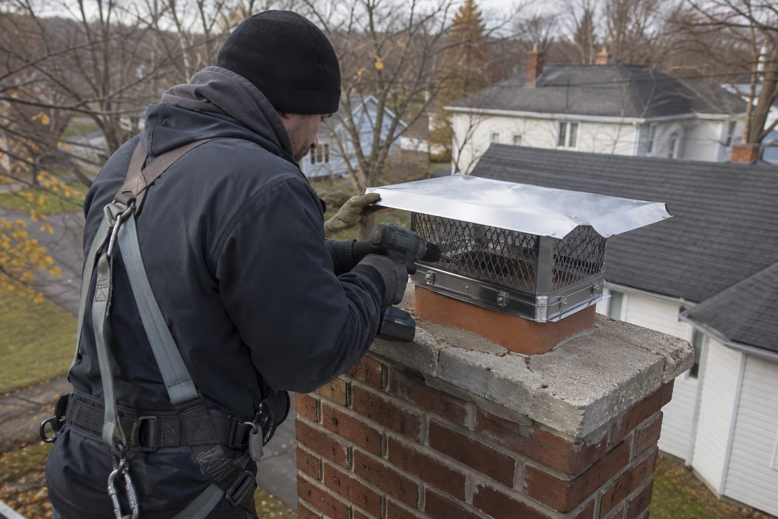 New stainless multi-flue chimney cap installed on a brick chimney in Syracuse, NY